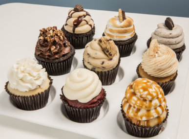nine different flavored cupcakes on a tray