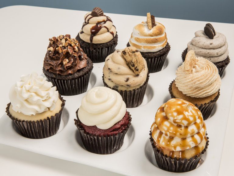 nine different flavored cupcakes on a tray
