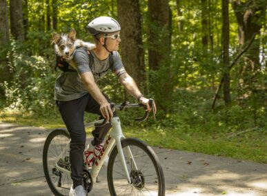 man and corgi riding bike through panola mountain state park