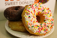 Sprinkle donut leaning against other donuts