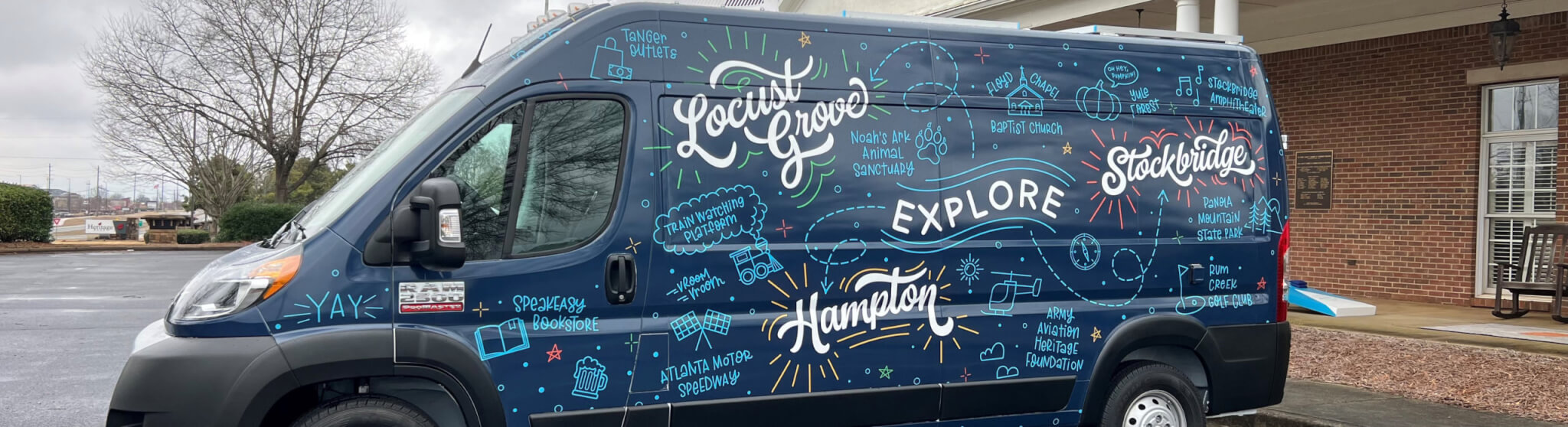 wrapped cargo van with city names in white and icons in light blue