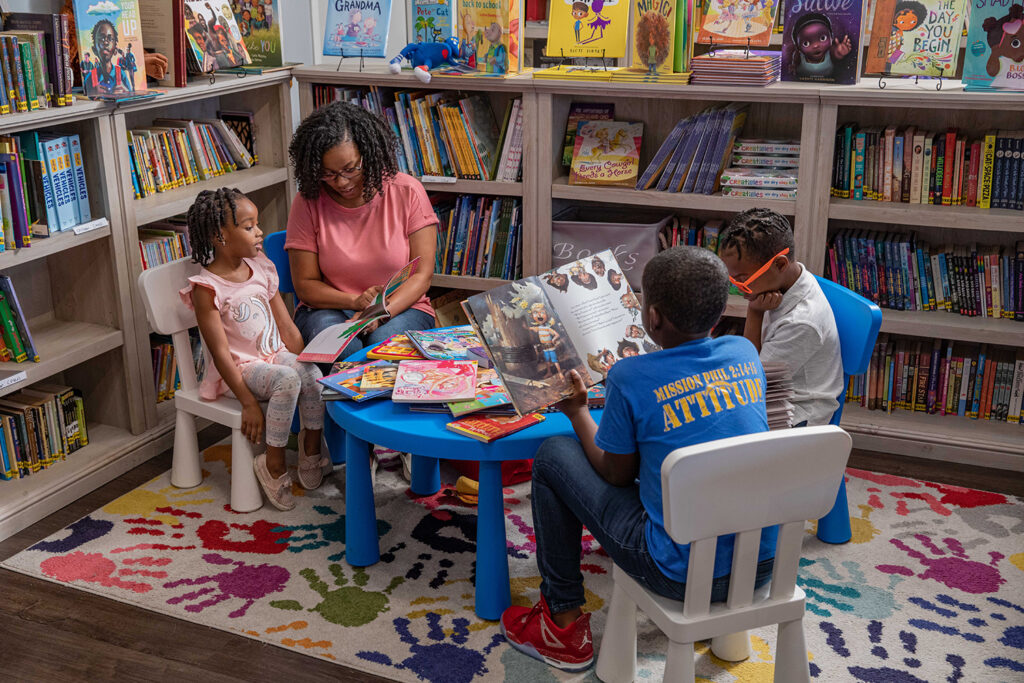 mother reads to children around small table