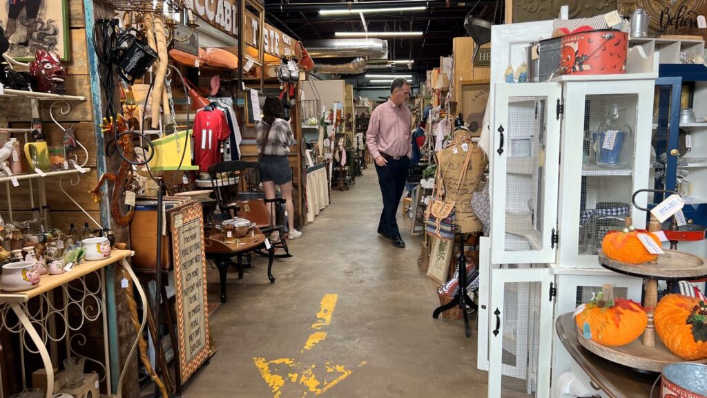 a man and woman looking at booths at an antique mall