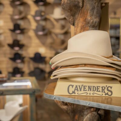 close up of a stack of white hats with hats on the wall in the background