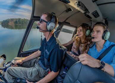 couple in a helicopter over water with a pilot in the front