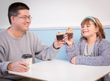 dad and daughter eating cupcakes from crumbles by nicole